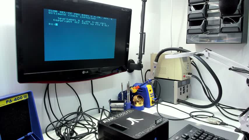 Atari 1088XEL running at a workbench, with blue text displayed on a monitor