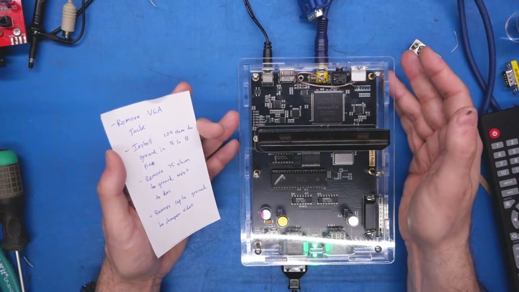 Acrylic-cased NES clone on Adrian’s Digital Basement workbench during video-output testing